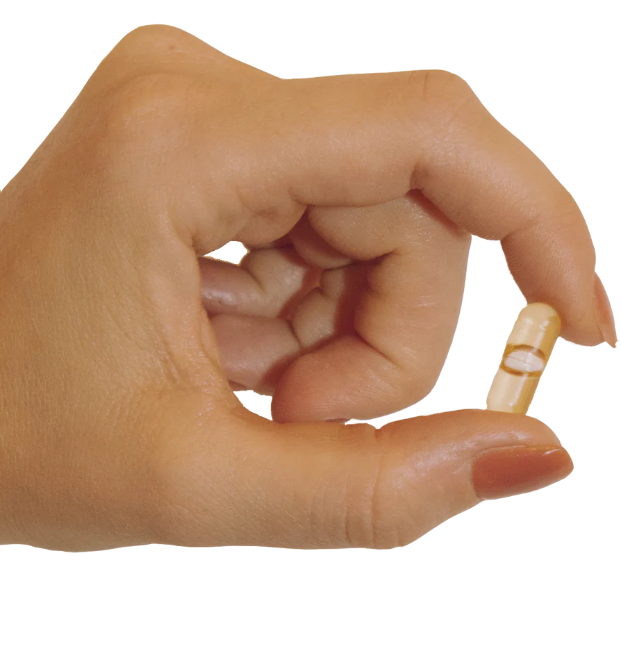 Hand pinching a yellow transparent capsule between thumb and index finger.